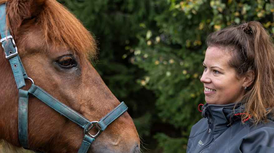 Nainen ja hevonen ovat vastakkain.