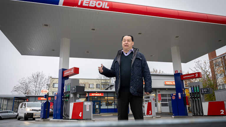 Taisto Nikkinen puhuu Teboilin huoltoaseman pihassa.