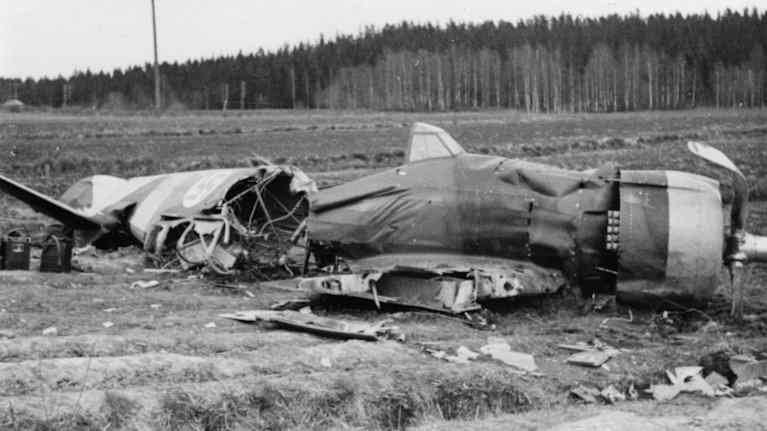 Suomen ilmavoimien Myrsky-hävittäjän tuhoutuneita jäänteitä pellon keskellä. Mustavalkoinen arkistokuva.