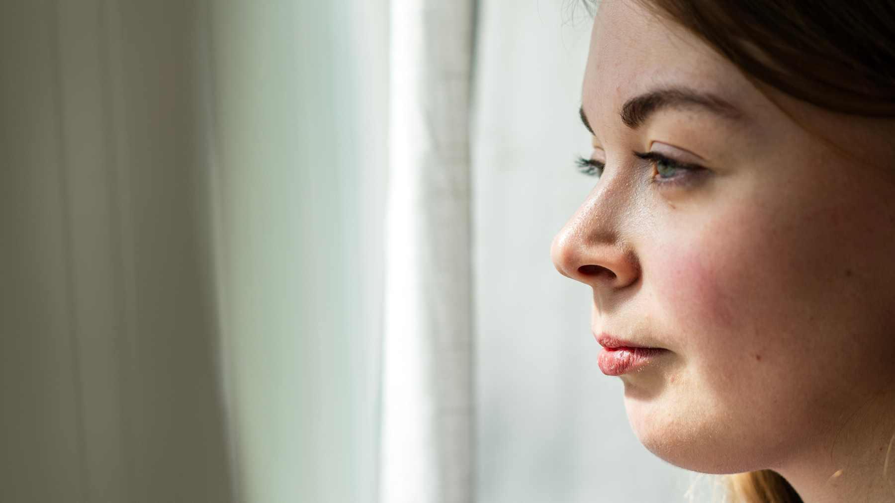 Ella Väliheikki katsoo ikkunasta ulos.