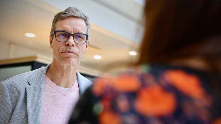 Mies katsoo naista, jonka hahmo näkyy kuvassa vain osittain.