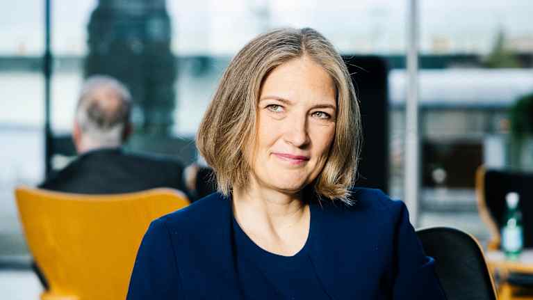 Henkilö istuu sisätiloissa moderneissa huonekaluissa.