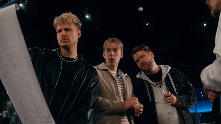 Henry Weckström, Niko Meuronen ja Santeri Hänninen katsovat ihmeissään Weckströmin auki vetämää paperirullaa.