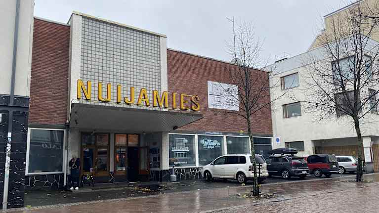 Kulttuuritilan ulko-oven lipan päällä on keltainen Nuijamies-kyltti.