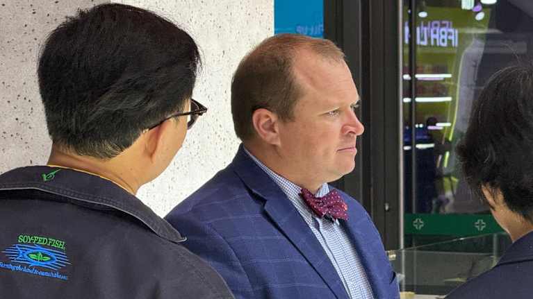 Soijafarmari Andrew Moore keskustelee messuvieraiden kanssa.