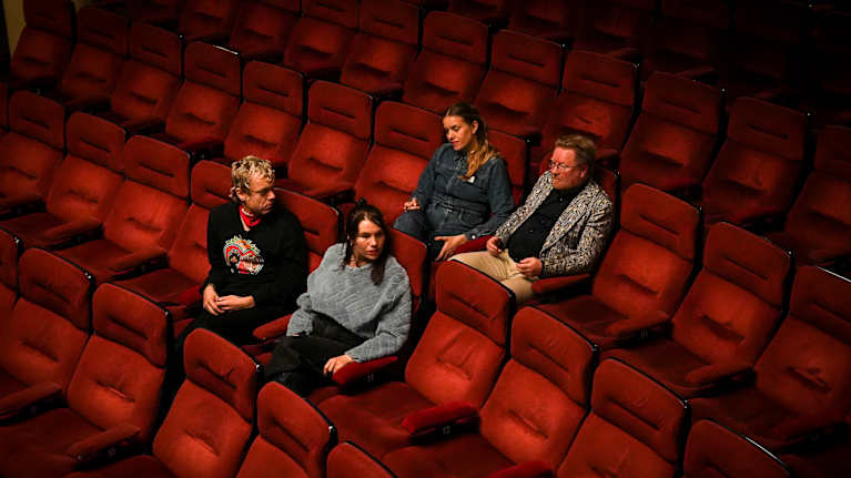 Ykspihlajan Kino-orkesterin jäsenet Anna ja Laura Airola, Miika Snåre sekä Ilkka Tolonen istumassa tyhjässä Orion-elokuvateatterissa. Kuvassa näkyy useita elokuvateatterin tuoleja.