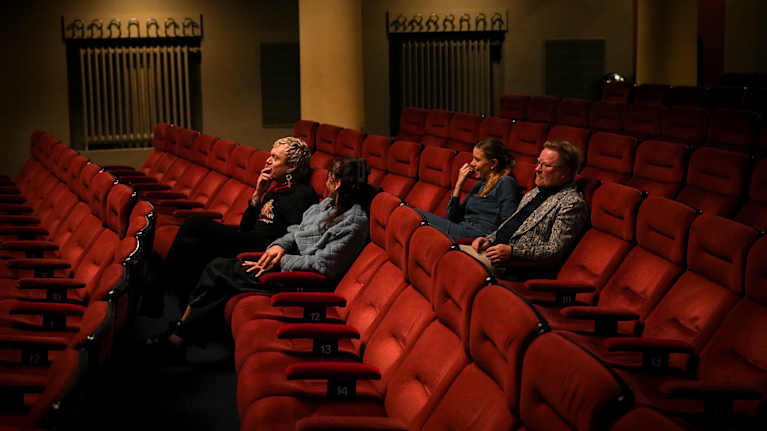 Ykspihlajan Kino-orkesterin jäsenet Anna ja Laura Airola, Miika Snåre sekä Ilkka Tolonen istumassa tyhjässä Orion-elokuvateatterissa. Kuvassa näkyy useita elokuvateatterin tuoleja.