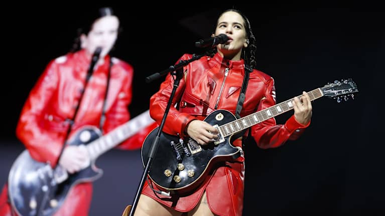 Rosalia soittaa kitaraa ja laulaa esiintymislavalla.