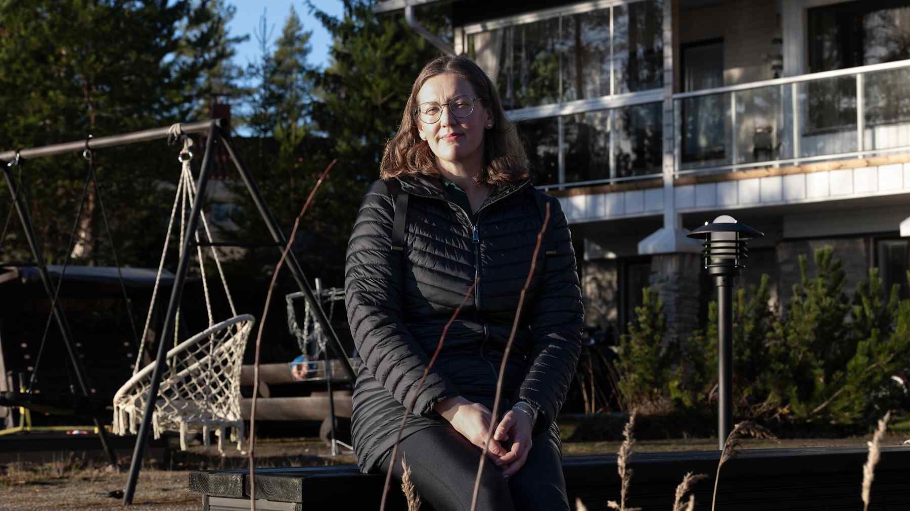 Hertta Niskanen istuu penkillä kotinsa edustalla.