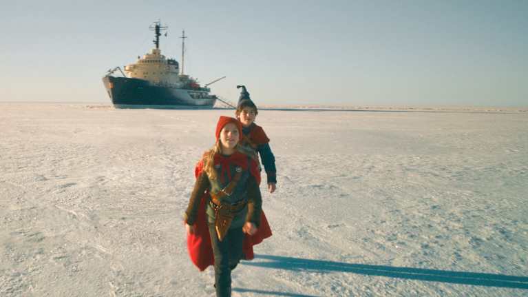 Lapset kävelevät jäällä ja taustalla näkyy jäänmurtaja Sampo. Kuva on ote Tonttu-elokuvasta.