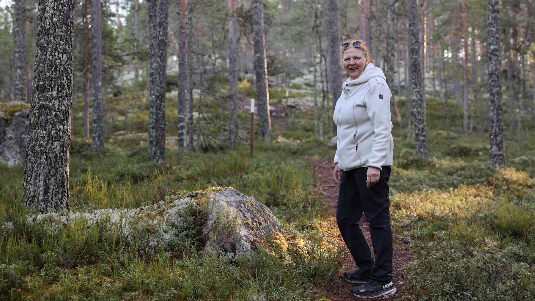 Marja-Liisa Pietiläinen seisoo polulla männikössä.