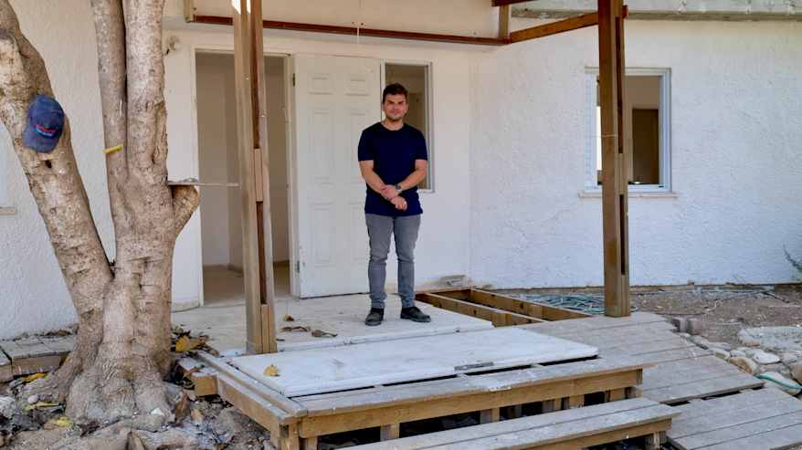 Mies seisoo remontoitavan talon oven edessä.