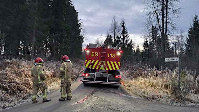Kaksi pelastuslaitoksen työntekijää ja paloauto.