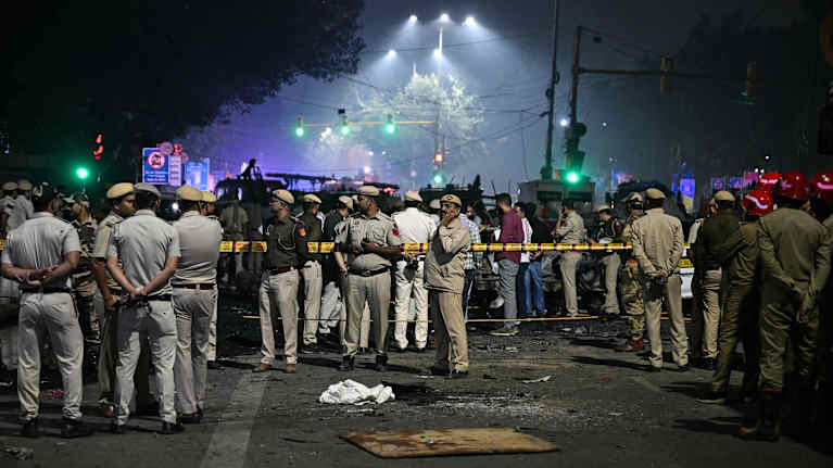 Lukuisia poliiseja seisoo eristetyn alueen läheisyydessä.