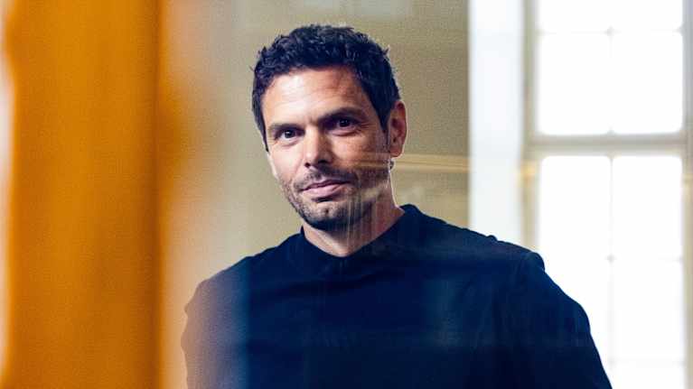 Peter Sarlin katsoo kameraan ovilasin läpi.