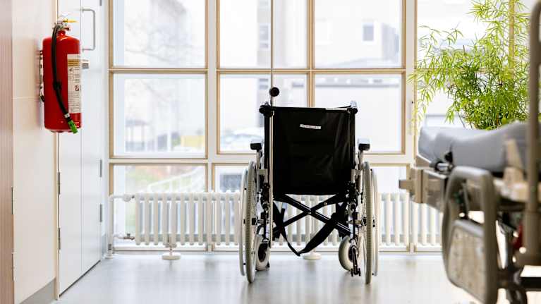 Rullatuoli sairaalan käytävällä ikkunan edessä.