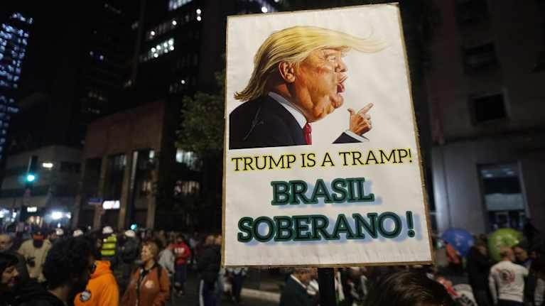 Mielenosoittajat kantavat kylttiä, jossa lukee Trump is a Tramp ja Brasil Soberano!