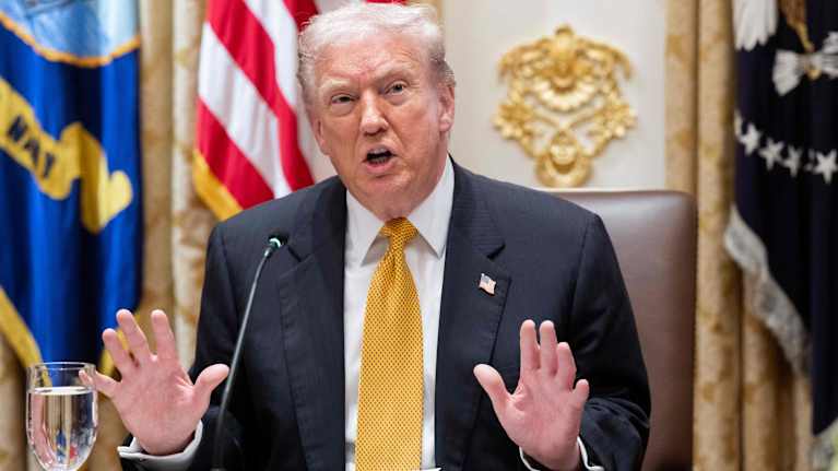 Donald Trump puhuu kämmenet ylhäällä.