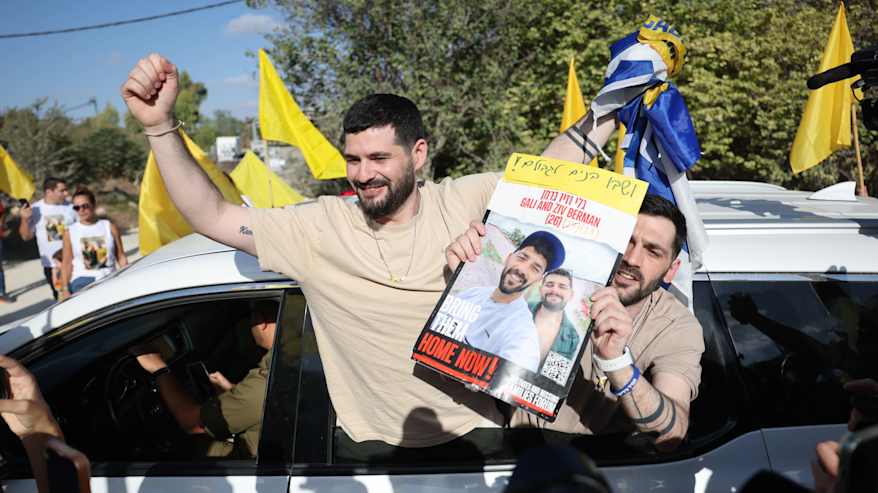 Kaksi miestä kurottautuu auton ikkunasta. Toinen pitelee kädessään kuvaa heistä.