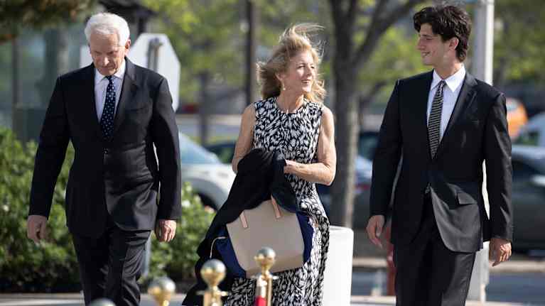 Nuorehko mies vanhemman pariskunnan kanssa. Kaikki ovat juhlallisesti pukeutuneita.