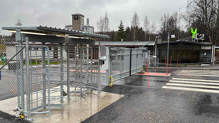 Metsä Boardin tehdasalueen sisäänkäynti Simpeleellä Rautjärvellä. Kuvassa näkyy turvaportti ja kääntöportti vierailijoille sekä työntekijöille.