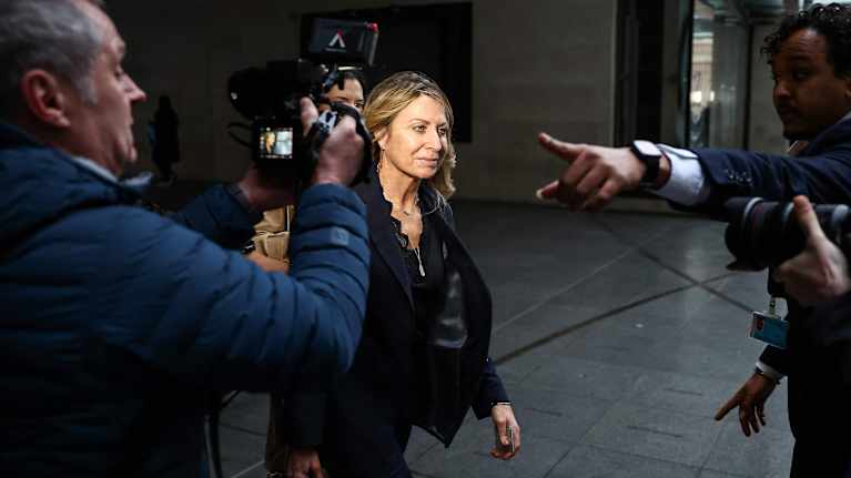 Deborah Turness kävelee kuvaajien ja toimittajien ympäröimänä BBC:n toimituksen ulkopuolella.