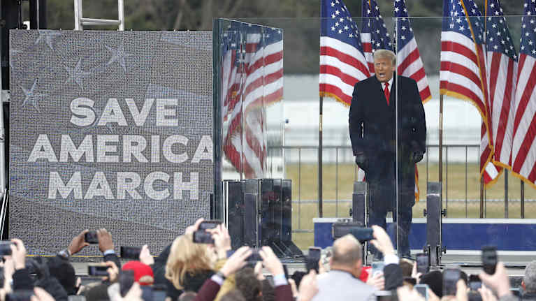 Donald Trump puhuu kannattajilleen Washington DC:ssä 2021. Taustalla Amerikan lippuja ja teksti "Save America March".