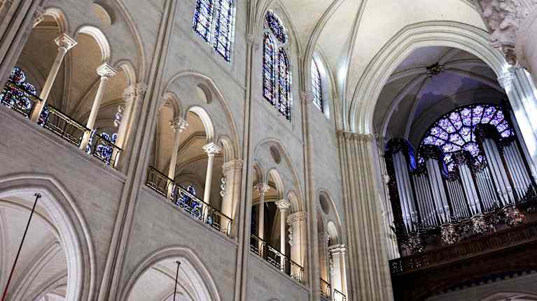 Notre-Damen katedraalin urkujen pillit keskilaivan päädyssä urkuparvella.  Urkupillien takaa näkyy pyöreä ikkuna, jossa värikkäitä lasimaalauksia.