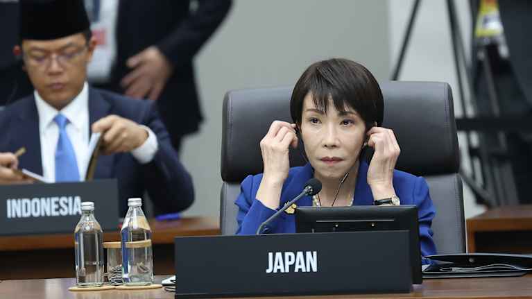 Japanin pääministeri Sanae Takaichi asettaa kuulokkeet korvilleen kokouksessa.