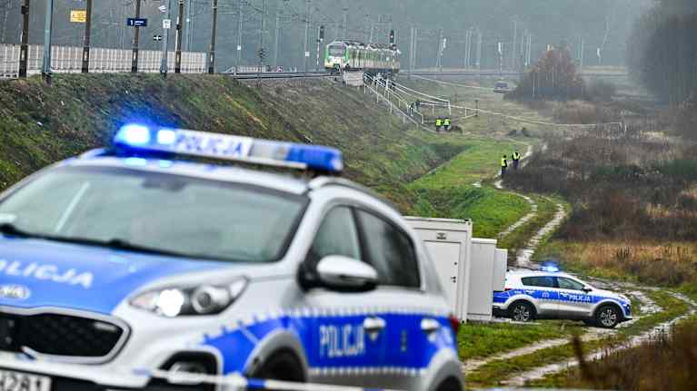 Erikoisjoukot ja poliisi tutkivat tuhoutuneen rautatieosuuden tapahtumapaikkaa Puolassa.
