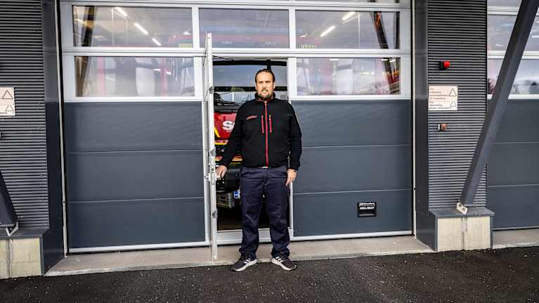 Juho Lahdenperä seisoo paloaseman autotallin etuovella.