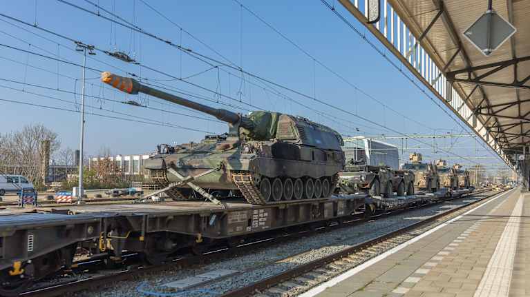 Juna kuljettaa taisteluvaunuja Hollannissa.
