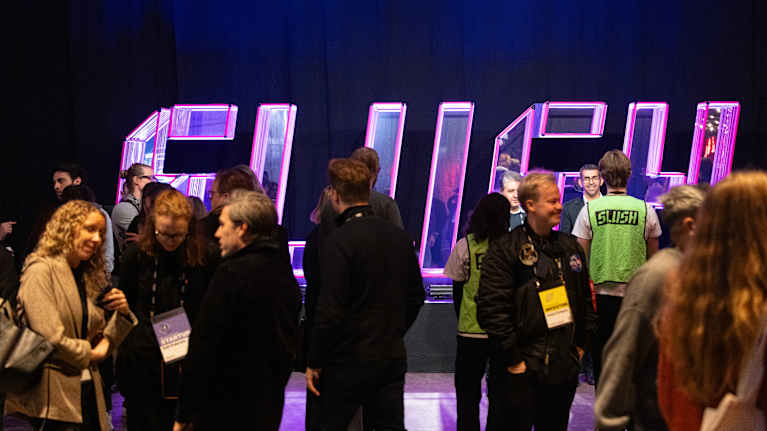 Ihmisiä slush logon edessä.