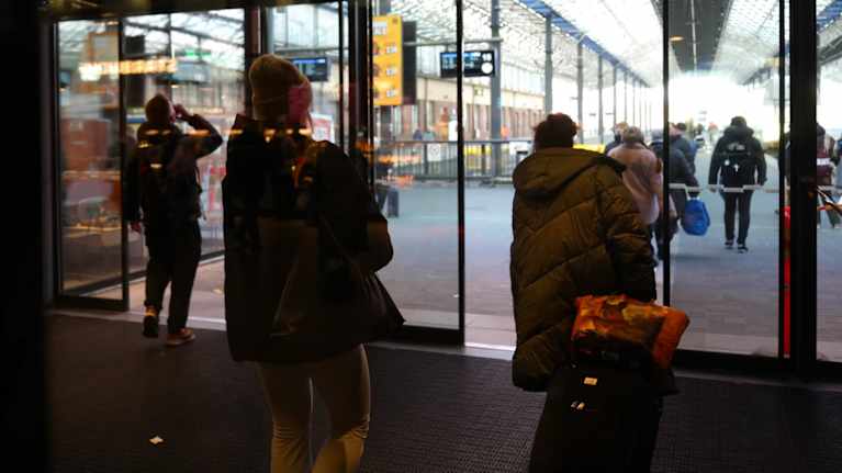 Ihmisiä liikkumassa Päärautatieaseman uusissa lasiovissa. 