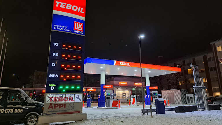 Joensuun Kirkkokadun Teboil marraskuisena iltana pimeässä. Maassa on lunta ja Teboilin valotaulut hohkavat. 