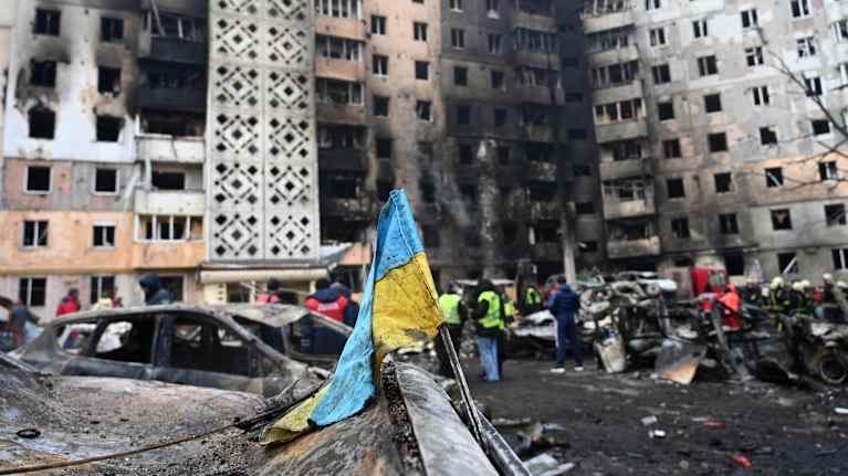 Kuva sodan runtelemasta rakennuksesta Ternopilissä Ukrainassa. Etualalla Ukrainan lipun riekale.