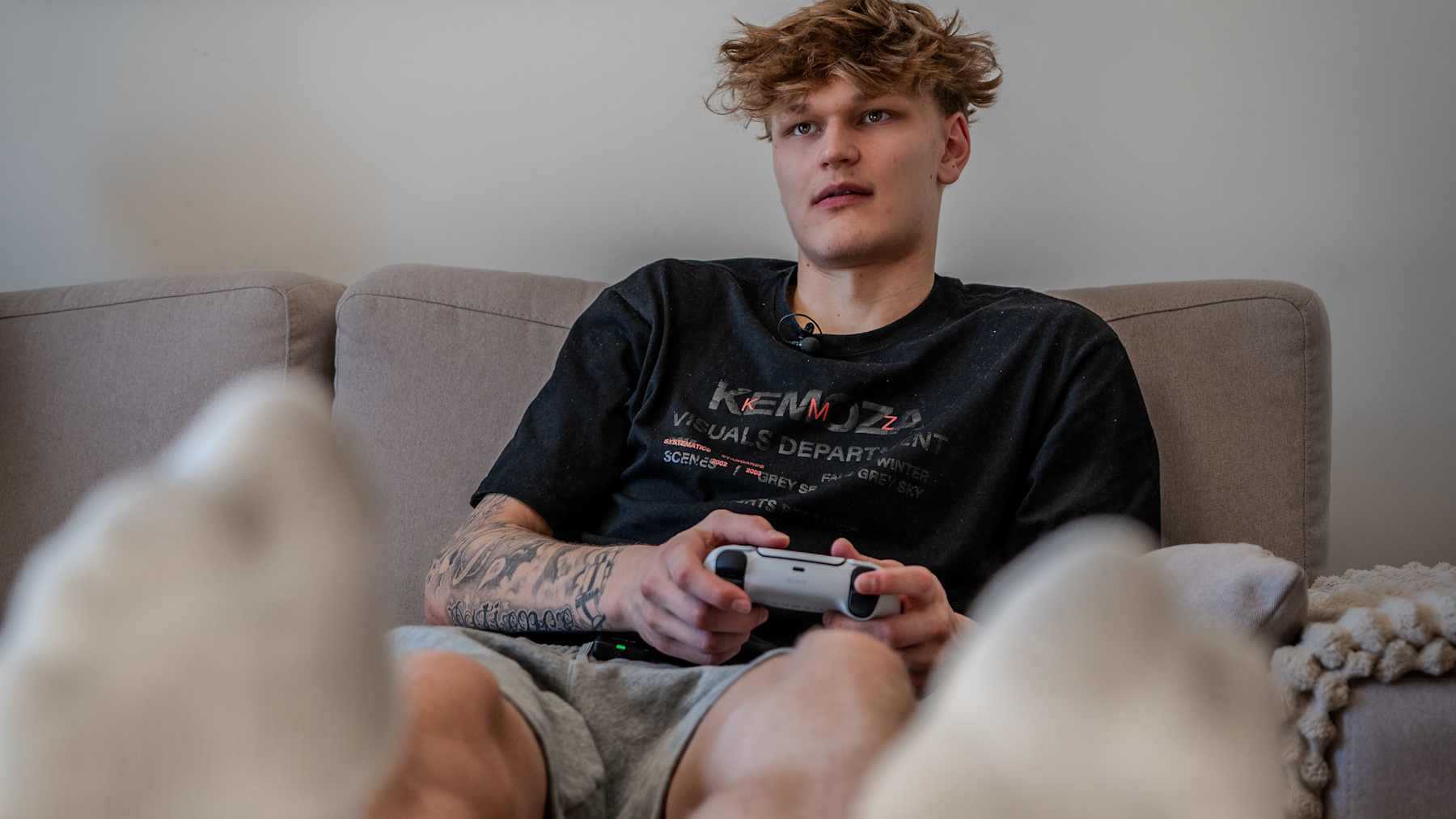 Miikka Muurinen pelaa pelikonsolia kotisohvallaan.