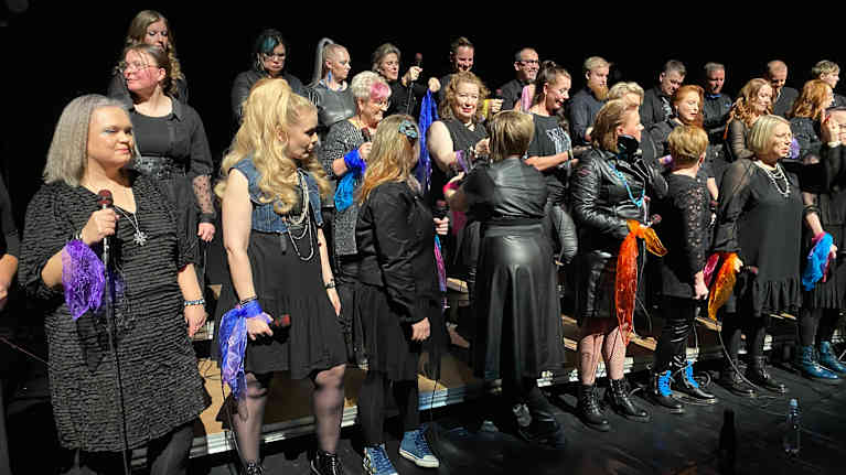 Kuoro valmistautuu laulamaan Dingoa sifonkihuivien pukemisella. 