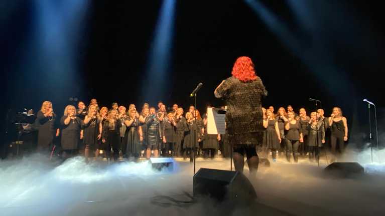 Varkauden laulun kuoro ja kuoronjohtaja lavalla. 