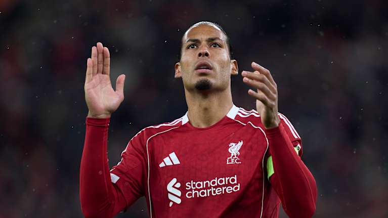 punapaitainen jalkapalloilija katsoo yläviistoon.