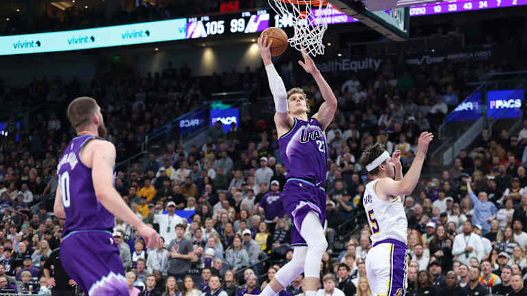 Lauri Markkanen hyppää kohti koria pallo kädessään.