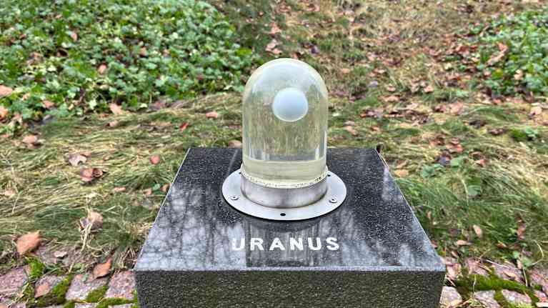 kuvassa on teos, jossa on kupu, jonka sisällä oleva pallo kuvaa Uranus-planeettaa.