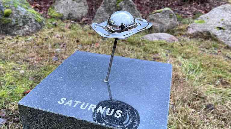 Kuvassa teos, joka kuvaa Saturnusta. Saturnuksen kehää on väännetty mutkalle.