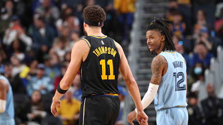 Klay Thompson (#11), Golden State Warriorsista, keskustelee Ja Morantin (#12), Memphis Grizzliesista, kanssa vuoden 2022 NBA:n pudotuspelien läntisen konferenssin välierien kolmannessa ottelussa 7. toukokuuta 2022 San Franciscossa.