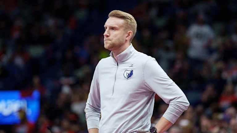 Memphis Grizzlies -koripallojoukkueen valmentaja seisoo kentän laidalla katsellen peliä.
