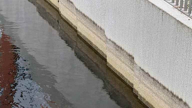 Betonisen rakenteen kyljessä näkyy veden piirtämiä vedenkorkeudesta kertovia kuvioita. Nyt veden pinta on matalalla.