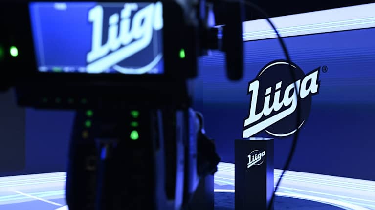 Liigan logo SM-liiga Oy:n yhtuökokouksen aikana tilassa, jossa lehdistö odottaa SM-liigan tiedotustilaisuuden alkua.