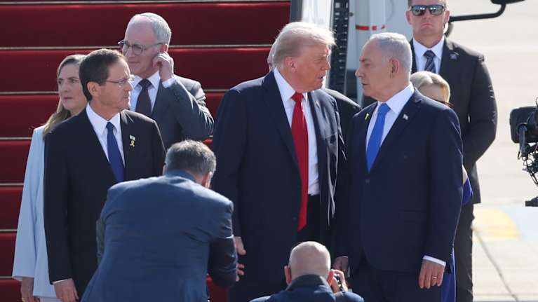 Donald Trump ja Benjamin Netanyahu keskustelevat lentokentällä. Isaac Herzog seisoo vieressä.