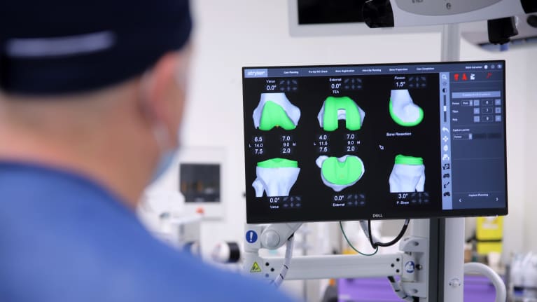 Ortopedi tutkii näytöltä 3D-kuvia leikkaussalissa.