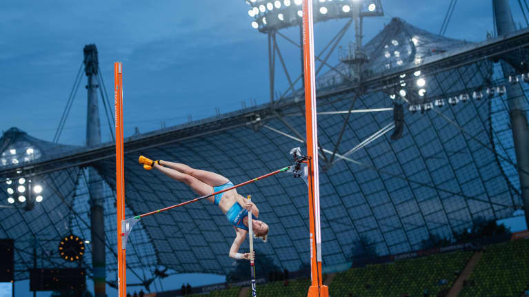 Wilma Murto ylittää riman Münchenin stadionin seiväshyppypaikalla. Taustalla näkyy valotorni ja stadionin kattorakenteita.